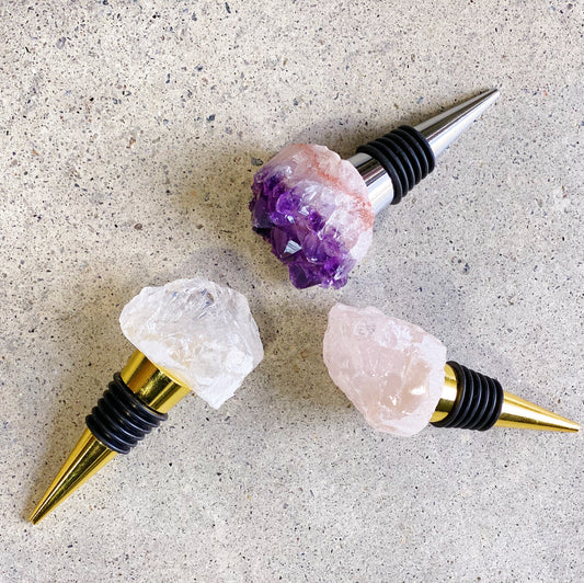 Three crystal bottle stoppers on a textured surface