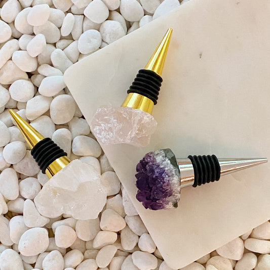 Wine bottle stoppers with crystal designs on pebbles