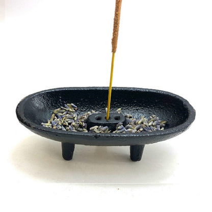 Black incense burner with incense sticks on a white background