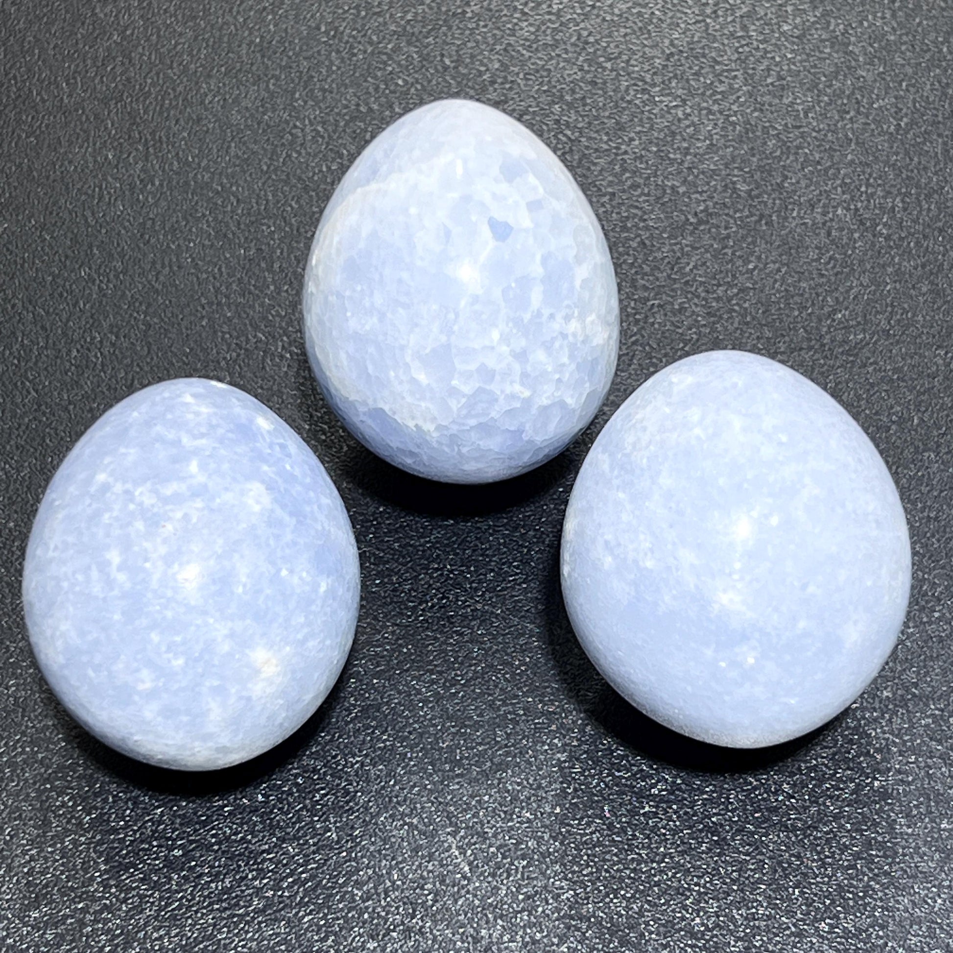 Blue Celestite egg shaped stones on a dark background
