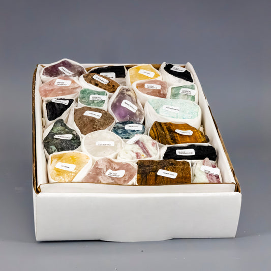 Box of various colored stones with labels on a gray background