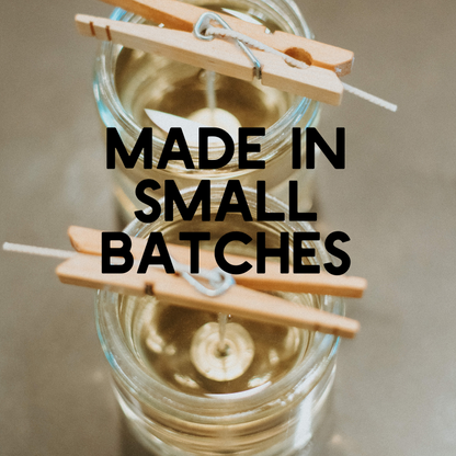 Glass jar with clothespins and text 'MADE IN SMALL BATCHES' on a neutral background