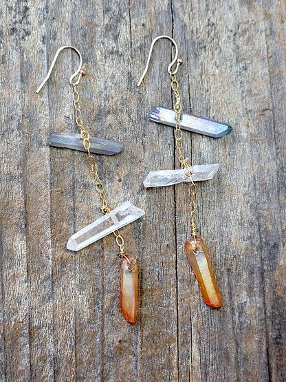 Pair of gold tone quartz crystal earrings on a wooden surface