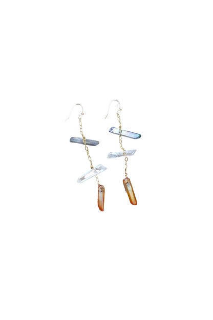 Pair of gold tone earrings with hanging quartz crystals on a white background