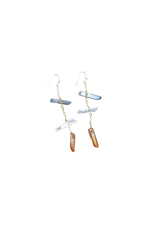 Pair of gold tone earrings with hanging quartz crystals on a white background