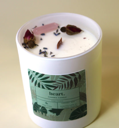 Candle with floral elements and a 'heart' label on a beige background