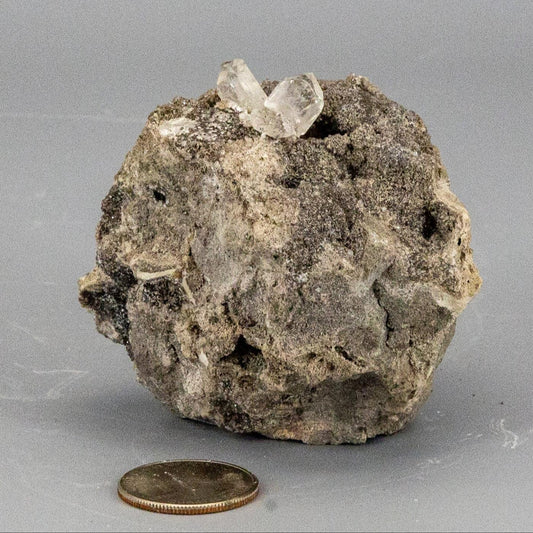 Mineral sample with herkimer diamond crystals on a gray background