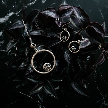 Circular jewelry set on dark leaves