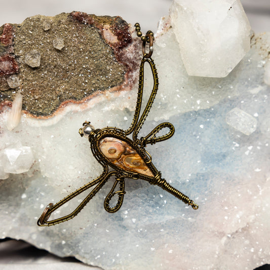 Bronze dragonfly Mexican agate pendant on a crystal background