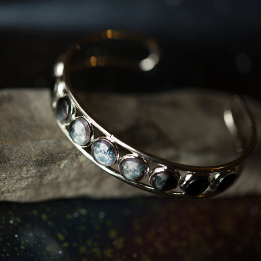 Silver bracelet with embedded stones on a dark background