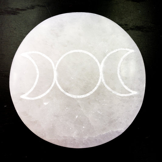Crystal with triple moon symbol on a dark background