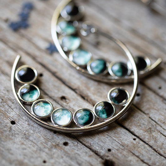 Hoop earrings with gemstone beads on a wooden surface
