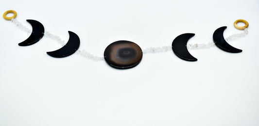Decorative moon phase horizontal wall hanging with black and gold elements on a white background