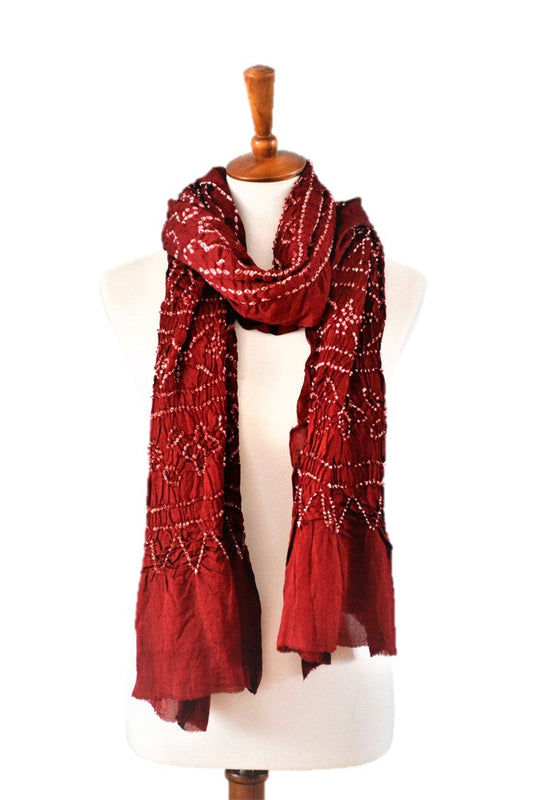 Red patterned silk scarf on a mannequin against a white background