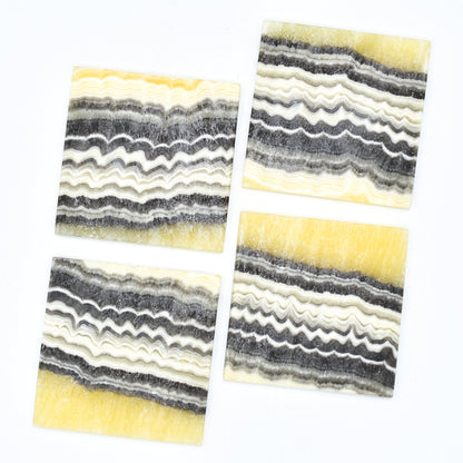 Four striped coasters with wavy pattern on a white background