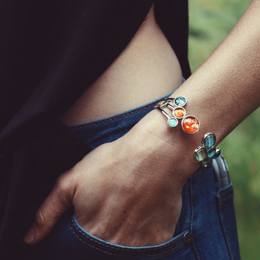 Person wearing a colorful bracelet on a blurred natural background