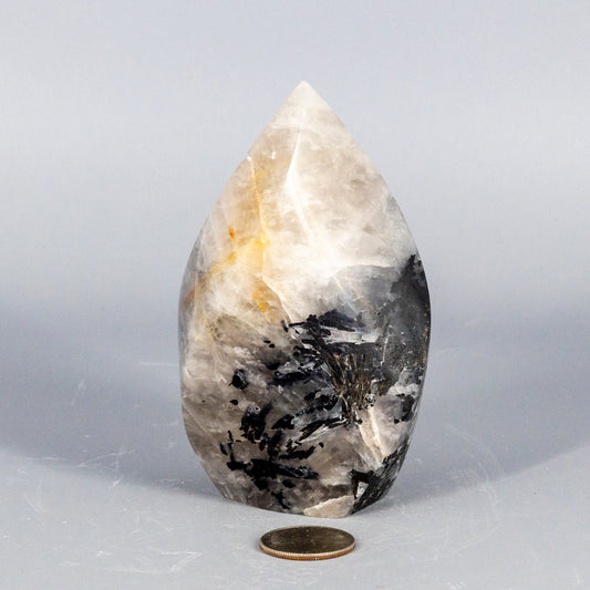 Decorative quartz with black tourmaline crystal with black and white patterns on a gray background