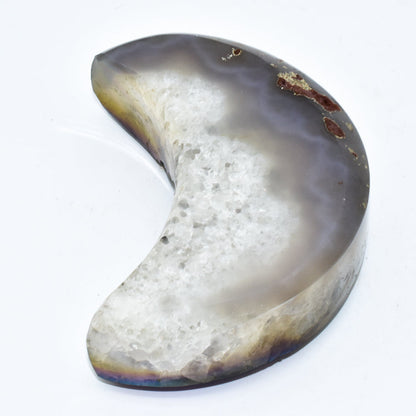 Half-moon shaped stone with a textured surface on a white background