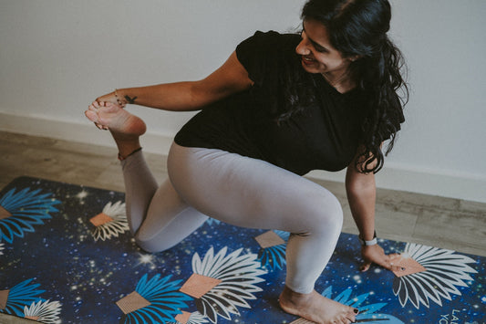 Woman practicing yoga on a floral mat in a home setting
