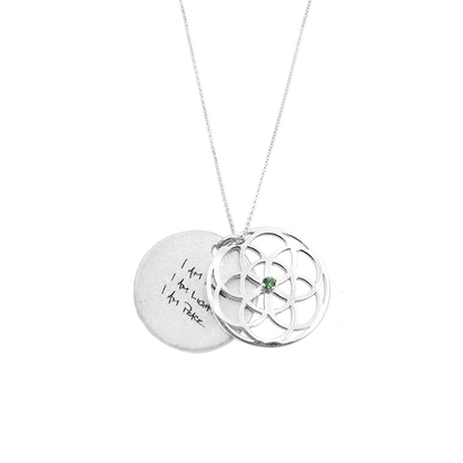 Silver necklace with seed of life pendant and engraved message on a white background