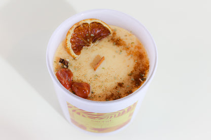 Sacral chakra candle with fruit pieces on a white background