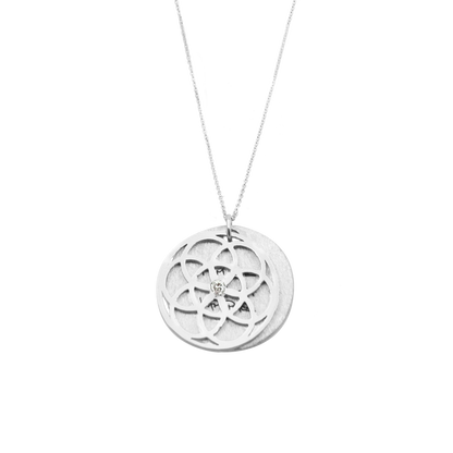 Silver necklace with a circular tree of life pendant on a white background
