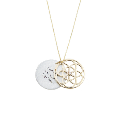 Necklace with a gold circular seed of life pendant and a white disc with text on a white background