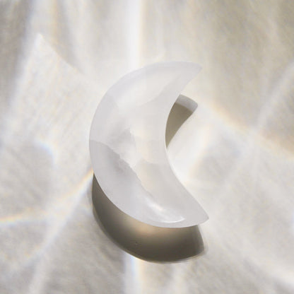 Selenite moon bowl on a neutral background