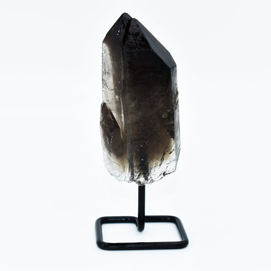 Smoky quartz crystal on a black stand against a white background