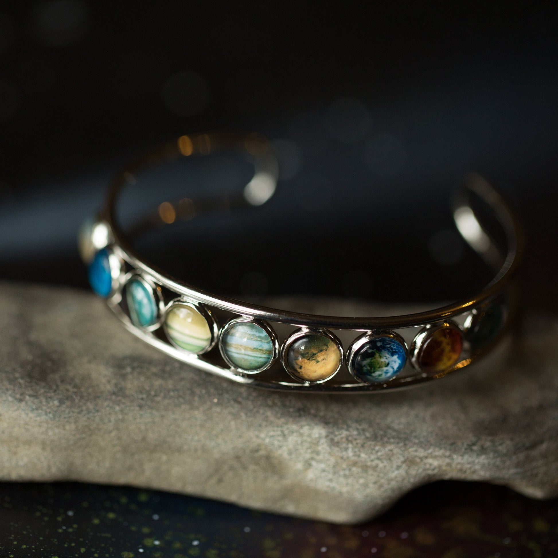 Silver bracelet with colorful stones on a dark background