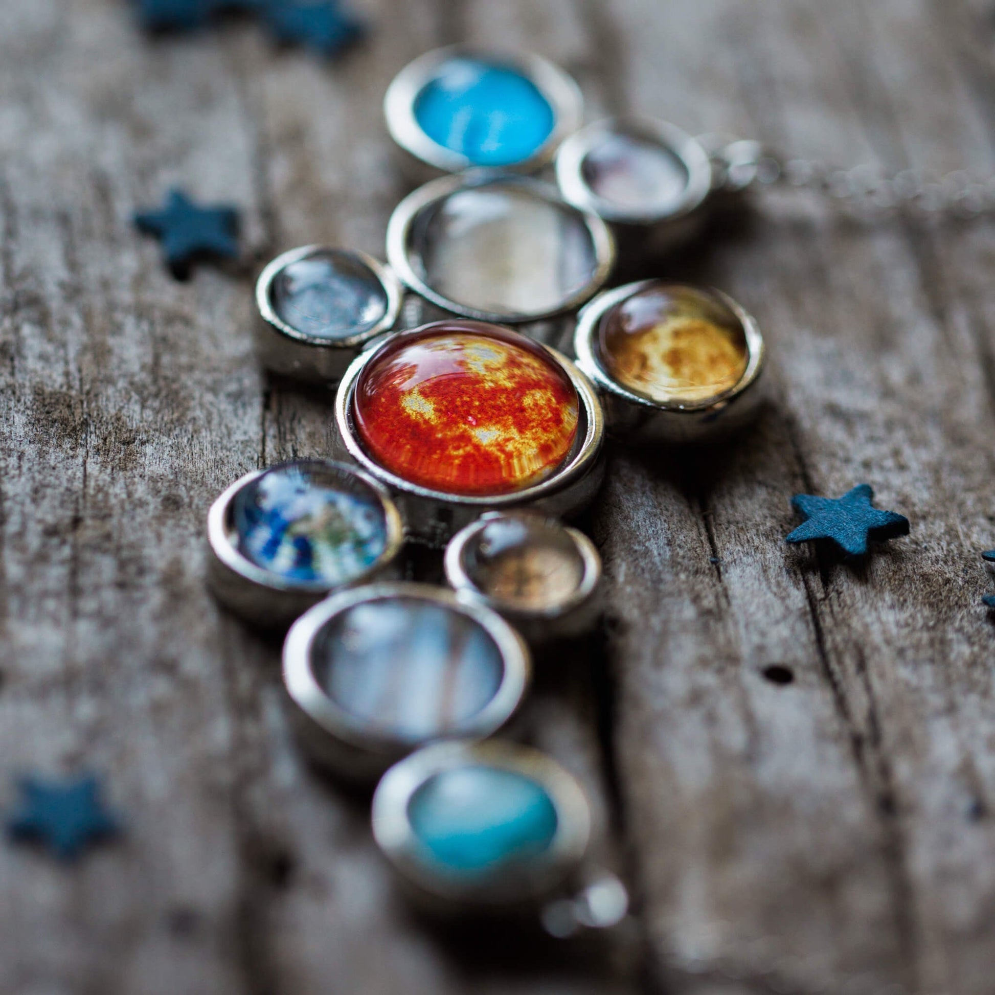 Solar system model on a wooden surface with star decorations