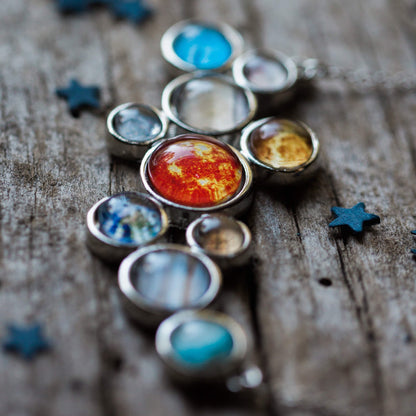 Solar system model on a wooden surface with star decorations