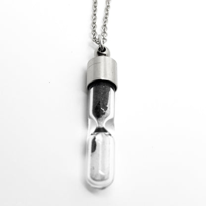 Silver hourglass-shaped pendant on a white background