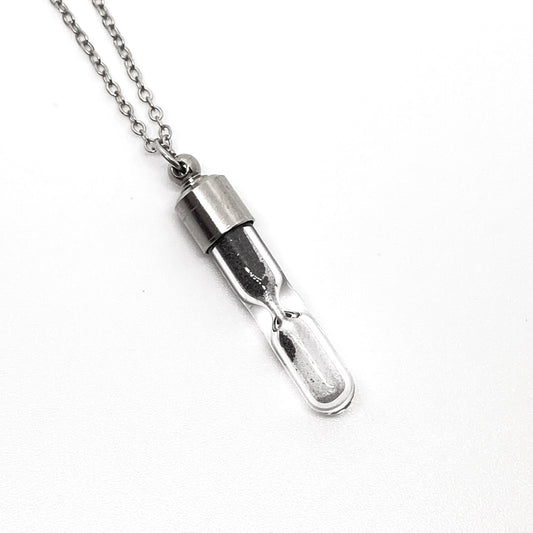 Silver hourglass pendant necklace on a white background