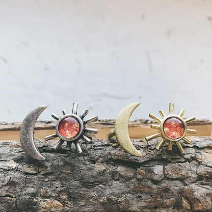 Pair of sun and moon rings on a wooden surface with a neutral background