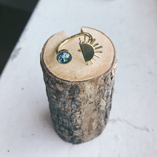 Gold ring with a green gemstone on a wooden block