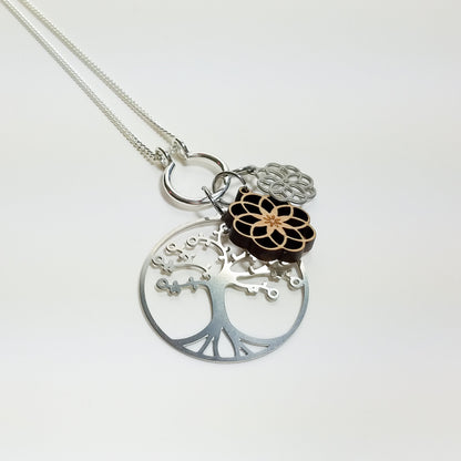 Necklace with tree of life, lotus, and infinity symbol pendants on a white background