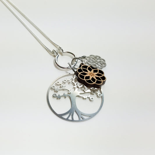 Necklace with tree of life, lotus, and infinity symbol pendants on a white background