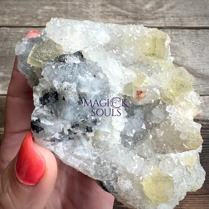 Fluorite crystal rock held by a hand.