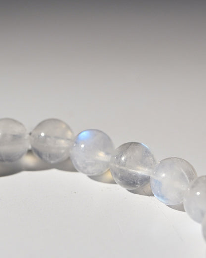 Close-up of a bracelet with rainbow moonstone beads on a white background