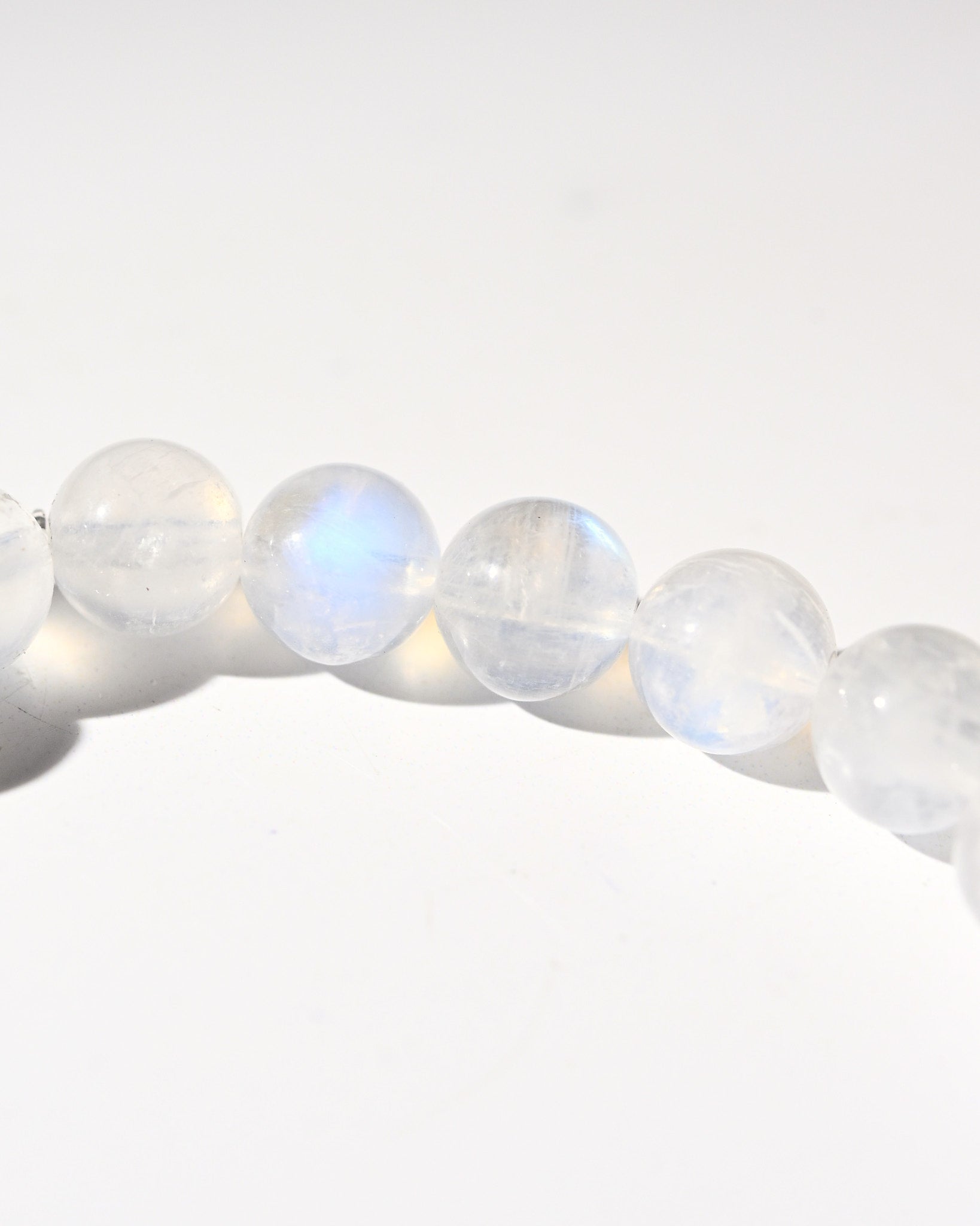 Close-up of rainbow moonstone beads on a white background